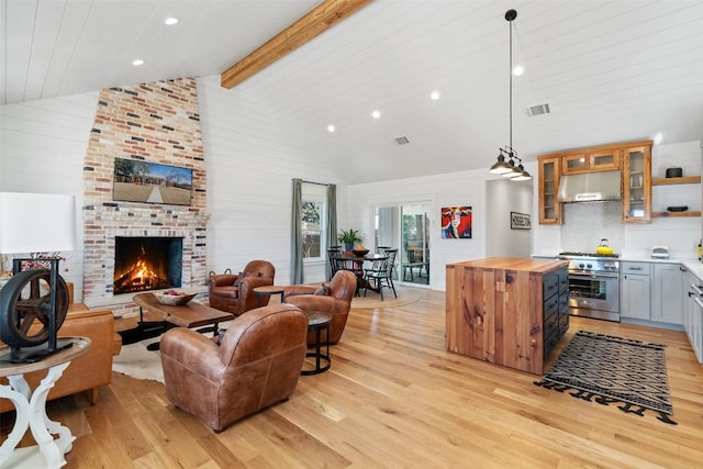 703 E 15th St, Georgetown, TX 78626 - living area with light wood-style flooring, high vaulted ceiling, recessed lighting, a fireplace, and beam ceiling