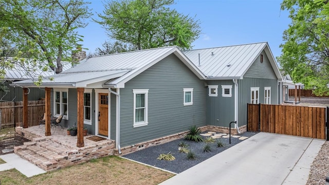 703 E 15th St, Georgetown, TX 78626 - rear view of property featuring metal roof and a patio area