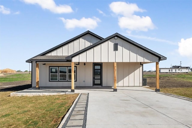 195 Bianca Cir, Del Valle, TX 78617 - modern inspired farmhouse with board and batten siding, a front lawn, a porch, a shingled roof, and driveway