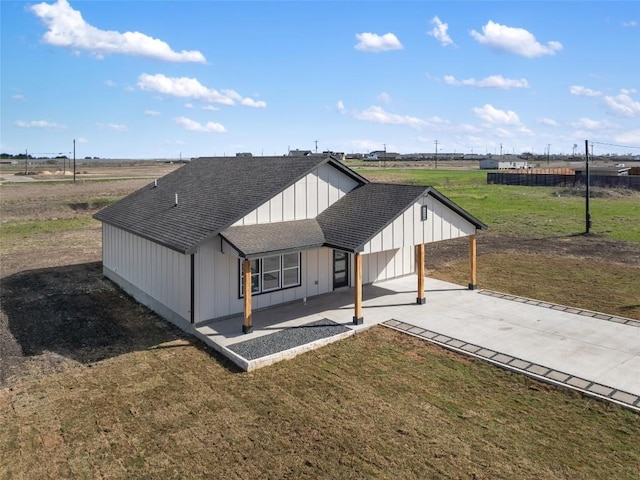 195 Bianca Cir, Del Valle, TX 78617 - view of front of home with a shingled roof, board and batten siding, a front yard, driveway, and a carport