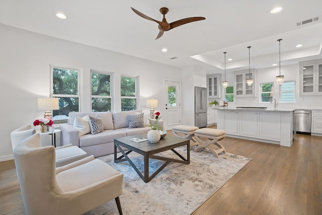 2110 Travis Heights Blvd, Austin, TX 78704 - living room with recessed lighting, plenty of natural light, ceiling fan, light wood-style floors, and a tray ceiling