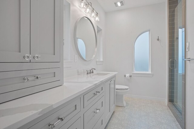 2110 Travis Heights Blvd, Austin, TX 78704 - bathroom with double vanity, toilet, a tile shower, tile patterned flooring, and baseboards