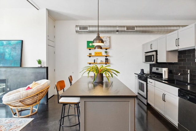 1601 E Cesar Chavez St Unit 202, Austin, TX 78702 - kitchen featuring stainless steel appliances, dark countertops, finished concrete flooring, decorative backsplash, and a kitchen island