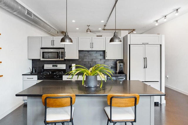 1601 E Cesar Chavez St Unit 202, Austin, TX 78702 - kitchen with stainless steel microwave, gas stove, recessed lighting, dark countertops, and a kitchen island