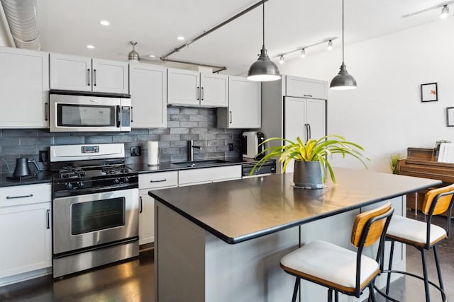 1601 E Cesar Chavez St Unit 202, Austin, TX 78702 - kitchen featuring stainless steel appliances, dark countertops, decorative backsplash, a center island, and recessed lighting