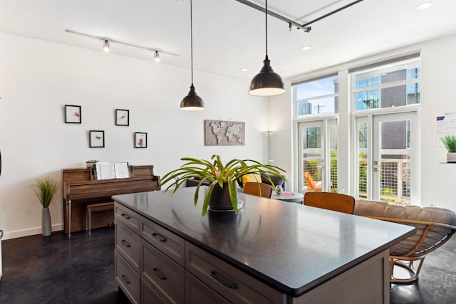 1601 E Cesar Chavez St Unit 202, Austin, TX 78702 - kitchen featuring track lighting, dark countertops, concrete flooring, hanging light fixtures, and recessed lighting