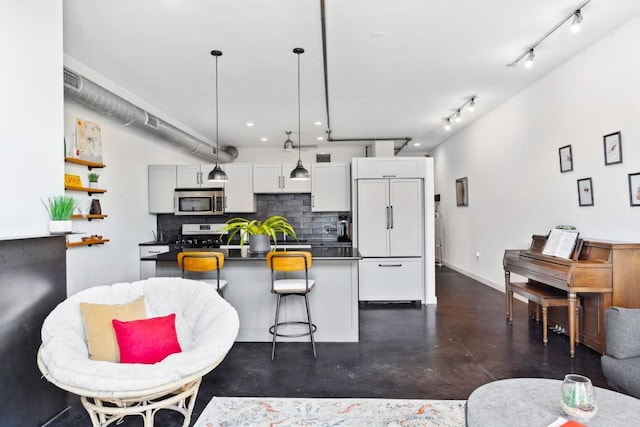 1601 E Cesar Chavez St Unit 202, Austin, TX 78702 - kitchen featuring stainless steel microwave, paneled built in refrigerator, concrete floors, dark countertops, and backsplash