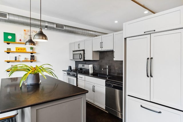 1601 E Cesar Chavez St Unit 202, Austin, TX 78702 - kitchen with stainless steel appliances, dark countertops, recessed lighting, backsplash, and decorative light fixtures