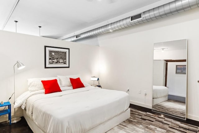 1601 E Cesar Chavez St Unit 202, Austin, TX 78702 - bedroom with baseboards, wood finished floors, and visible vents