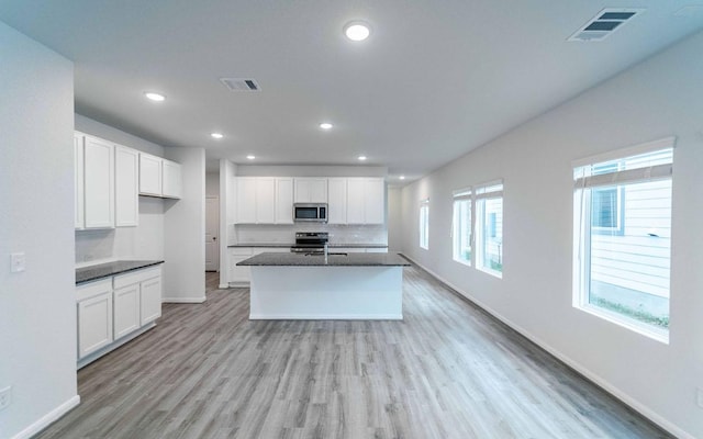 201 Lt Rusty Dr, Jarrell, TX 76537 - kitchen with stainless steel appliances, light wood finished floors, white cabinets, baseboards, and recessed lighting