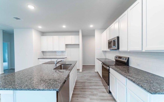 201 Lt Rusty Dr, Jarrell, TX 76537 - kitchen featuring stainless steel appliances, a sink, decorative backsplash, light wood finished floors, and recessed lighting