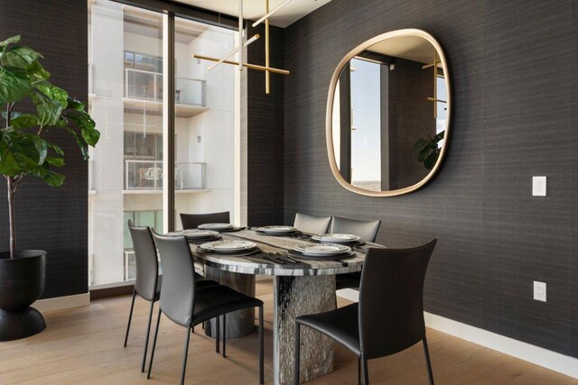 44 E Ave Unit 2601, Austin, TX 78701 - dining room featuring wallpapered walls, wood finished floors, and baseboards
