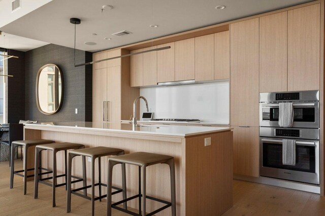 44 E Ave Unit 2601, Austin, TX 78701 - kitchen featuring double oven, modern cabinets, light wood-style flooring, and light countertops