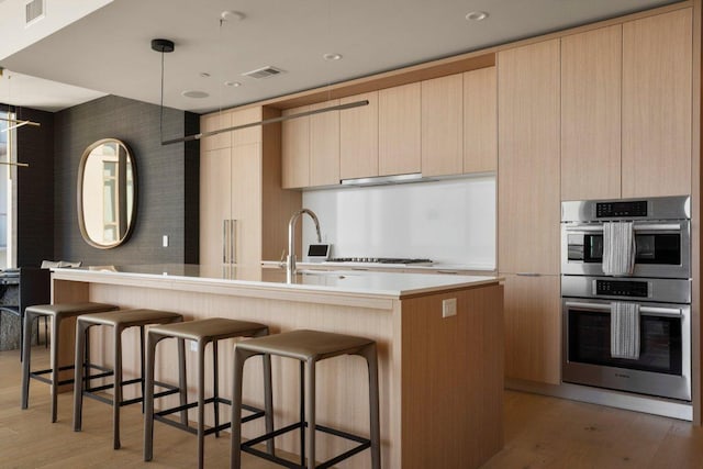 44 E Ave Unit 2601, Austin, TX 78701 - kitchen with double oven, modern cabinets, light wood-style flooring, and light countertops