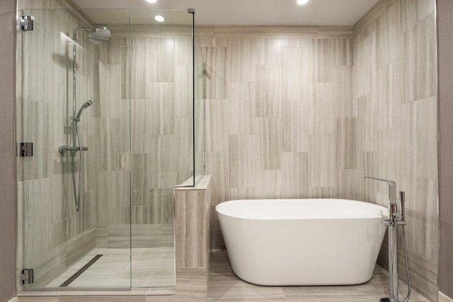 44 E Ave Unit 2601, Austin, TX 78701 - full bath with a freestanding tub, a shower stall, tile walls, and recessed lighting