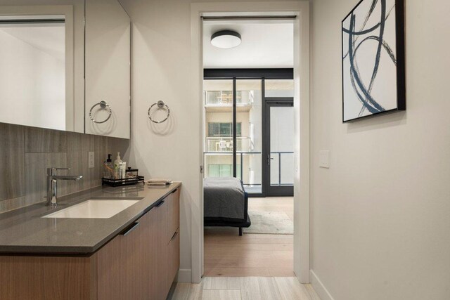 44 E Ave Unit 2601, Austin, TX 78701 - bathroom with vanity, tasteful backsplash, wood finished floors, and baseboards