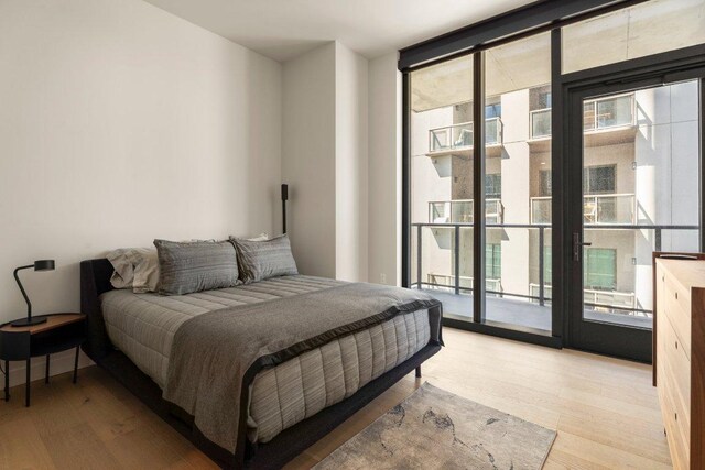 44 E Ave Unit 2601, Austin, TX 78701 - bedroom featuring access to exterior, expansive windows, and light wood finished floors