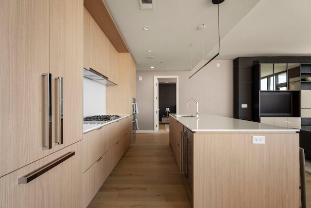 44 E Ave Unit 2601, Austin, TX 78701 - kitchen featuring modern cabinets, light brown cabinets, a sink, an island with sink, and recessed lighting