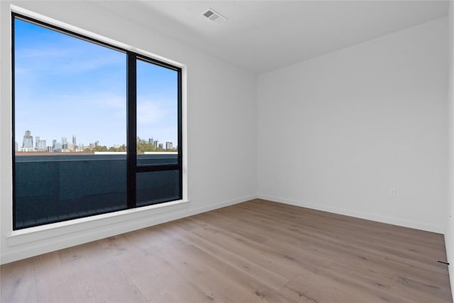 2209 S 1st St Unit 407, Austin, TX 78704 - empty room featuring plenty of natural light, wood finished floors, and a skyline view