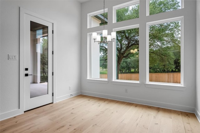 1304 Novara Trl, Leander, TX 78641 - doorway with healthy amount of natural light, a chandelier, light wood finished floors, and a high ceiling