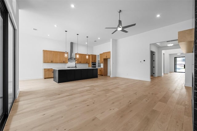 1304 Novara Trl, Leander, TX 78641 - kitchen with wall chimney exhaust hood, open floor plan, ceiling fan, light countertops, and recessed lighting