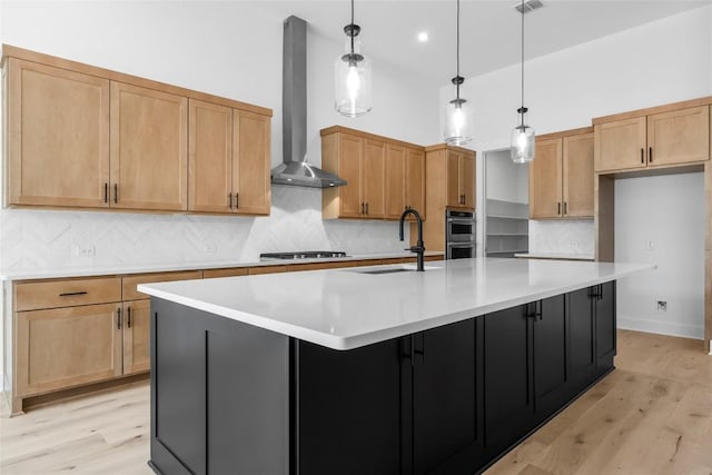 1304 Novara Trl, Leander, TX 78641 - kitchen with wall chimney range hood, appliances with stainless steel finishes, a spacious island, light wood-style floors, and a high ceiling