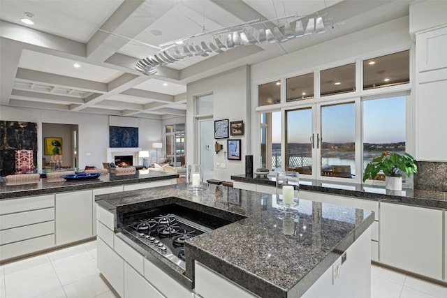 715 Cutlass, Lakeway, TX 78734 - kitchen with light tile patterned flooring, a lit fireplace, open floor plan, white cabinets, and coffered ceiling