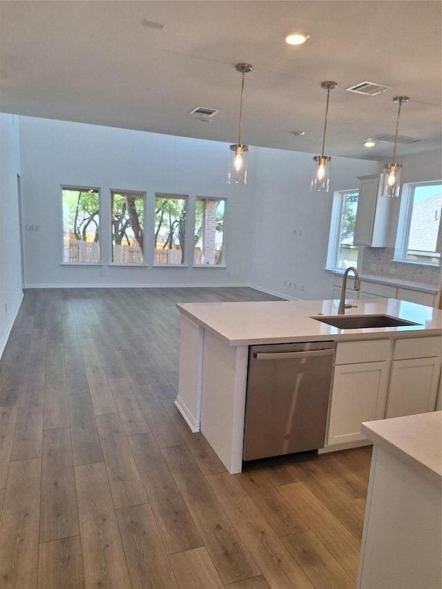 kitchen with white cabinets, dishwasher, visible vents, and a sink