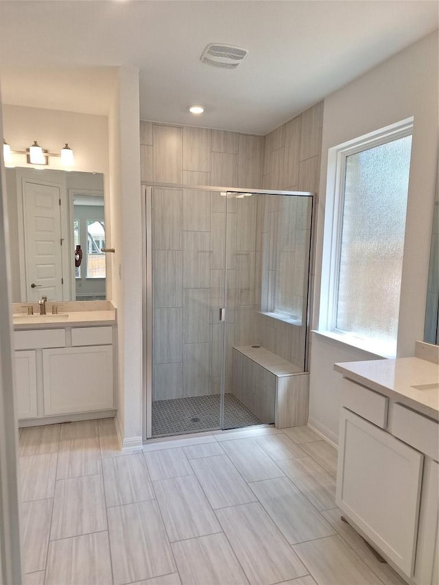 bathroom with visible vents, baseboards, a stall shower, and a healthy amount of sunlight
