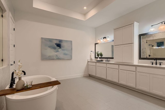 10928 Seawall Dr, Austin, TX 78737 - bathroom with double vanity, a soaking tub, recessed lighting, a tray ceiling, and tile patterned flooring