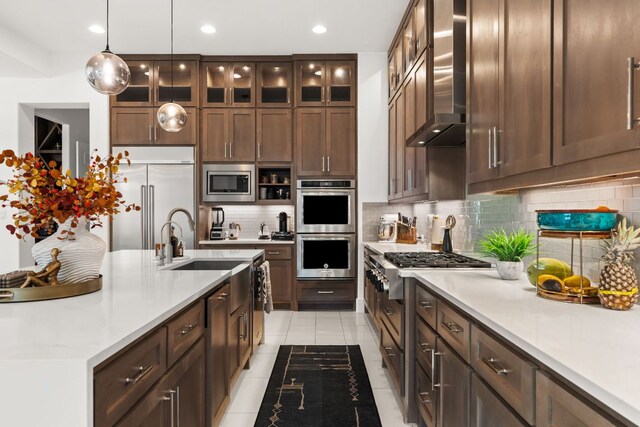 702 Serene Estates Dr, Austin, TX 78738 - kitchen with wall chimney range hood, built in appliances, light tile patterned floors, backsplash, and recessed lighting