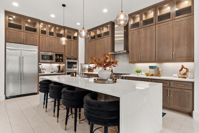 702 Serene Estates Dr, Austin, TX 78738 - kitchen with built in appliances, a center island with sink, backsplash, wall chimney range hood, and light countertops