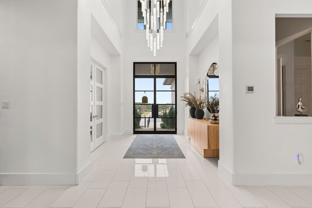 702 Serene Estates Dr, Austin, TX 78738 - tiled entryway featuring baseboards, a chandelier, a high ceiling, and french doors