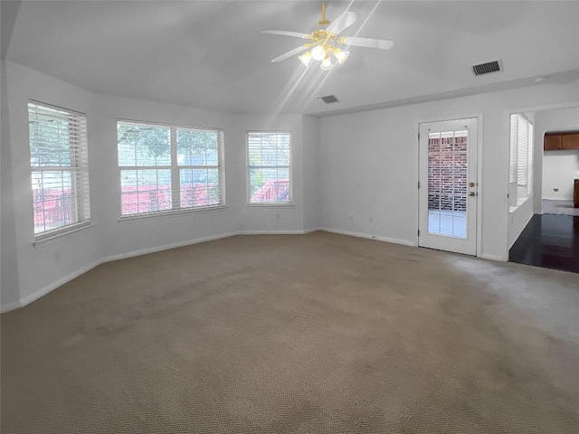 unfurnished living room with lofted ceiling, visible vents, carpet floors, and ceiling fan