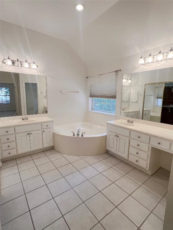 2804 Butler National Dr, Pflugerville, TX 78660 - full bath featuring vaulted ceiling, tile patterned floors, a garden tub, and two vanities