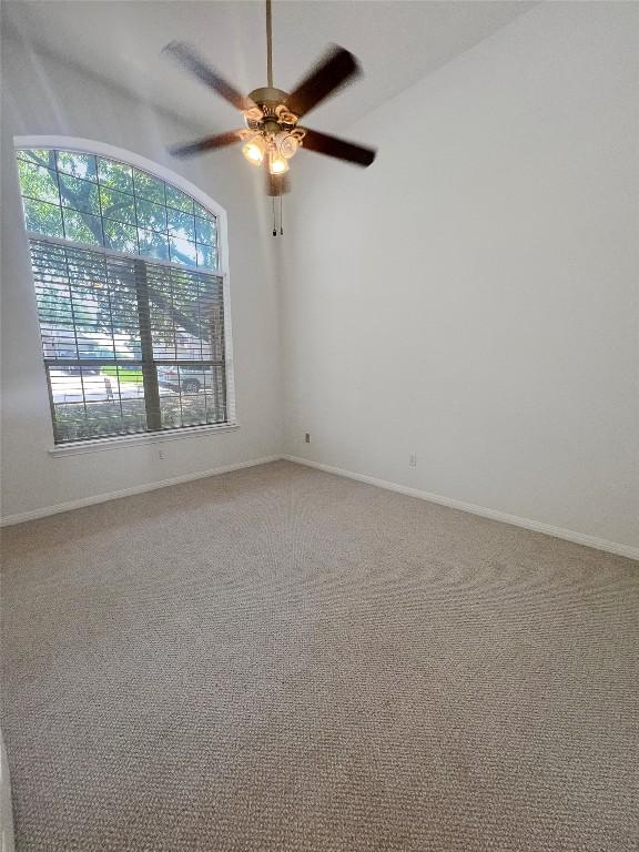 2804 Butler National Dr, Pflugerville, TX 78660 - empty room featuring a ceiling fan, carpet, baseboards, and lofted ceiling