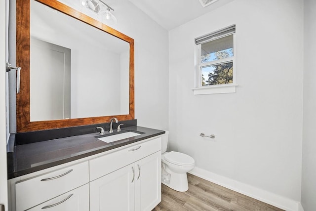 21603 Thomas Cv, Lago Vista, TX 78645 - bathroom featuring vanity, toilet, wood finished floors, and baseboards