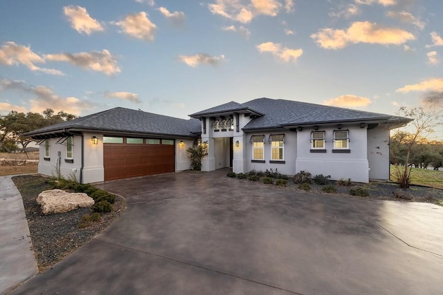 21603 Thomas Cv, Lago Vista, TX 78645 - prairie-style home featuring stucco siding, driveway, a garage, and roof with shingles