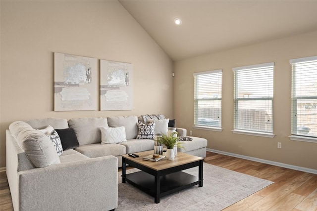 122 Denton Dr, Hutto, TX 78634 - living area with lofted ceiling, recessed lighting, light wood-style floors, and baseboards