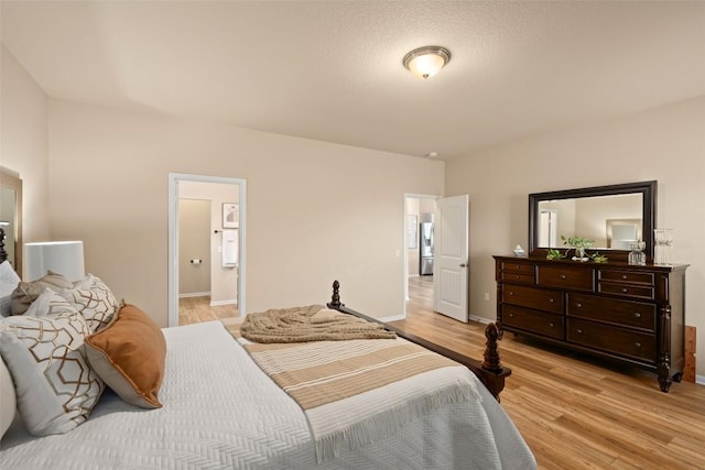122 Denton Dr, Hutto, TX 78634 - bedroom featuring connected bathroom, baseboards, and light wood-style floors