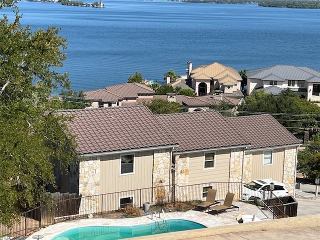view of pool featuring a patio area, a fenced in pool, fence, and a water view