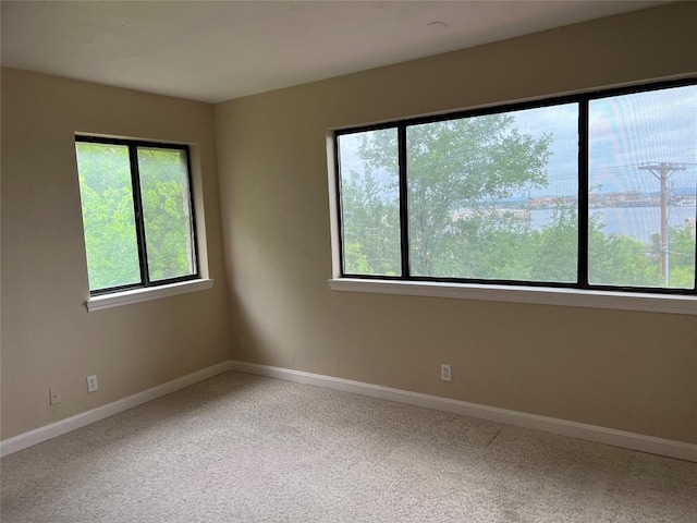 carpeted spare room with baseboards