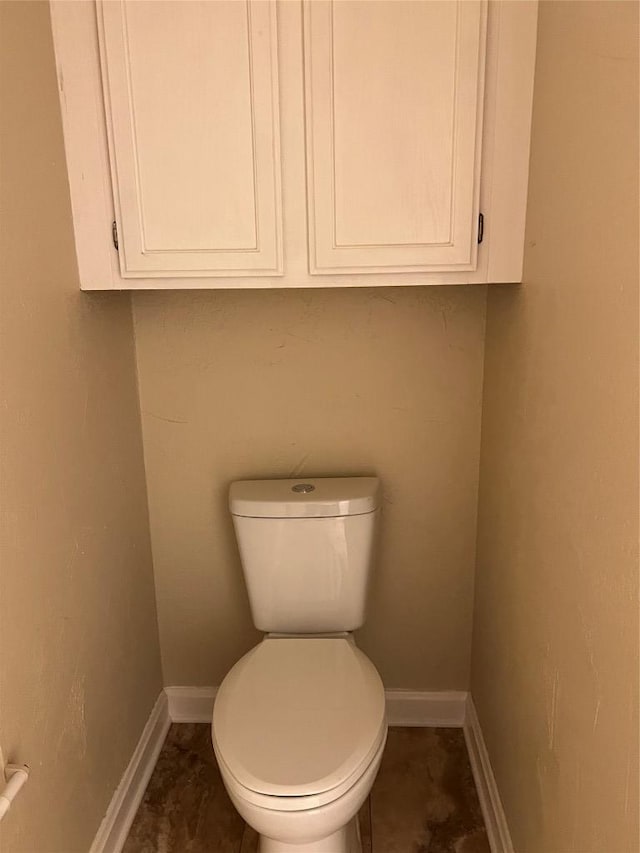 bathroom featuring baseboards and toilet