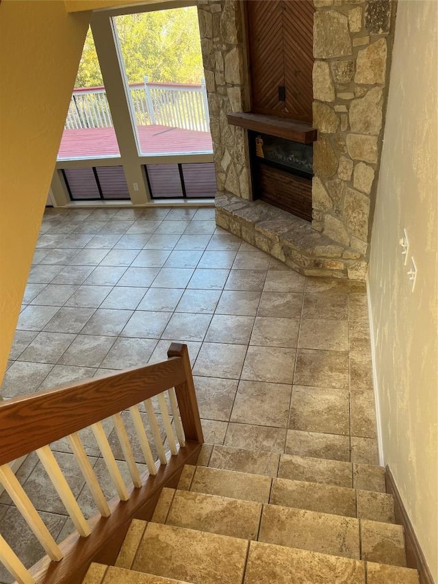 stairs with baseboards, a fireplace, and a textured wall