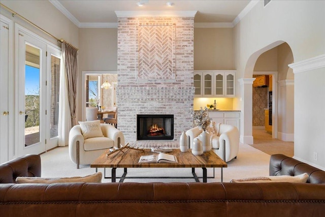 13601 Lone Rider Trl, Austin, TX 78738 - living area featuring light carpet, arched walkways, a brick fireplace, ornamental molding, and baseboards