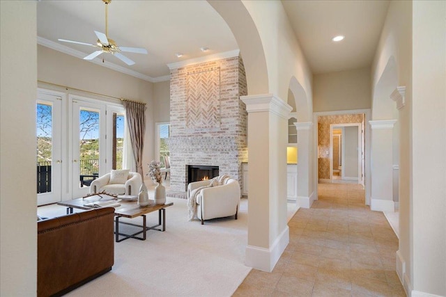 13601 Lone Rider Trl, Austin, TX 78738 - living room with arched walkways, a ceiling fan, a brick fireplace, a high ceiling, and light tile patterned floors