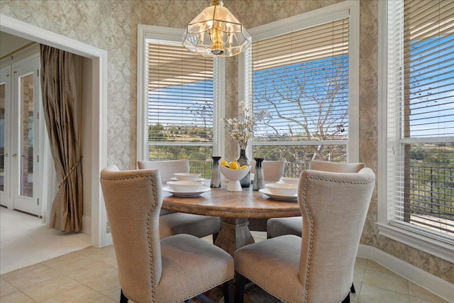 13601 Lone Rider Trl, Austin, TX 78738 - dining space with wallpapered walls, a chandelier, light tile patterned flooring, and baseboards
