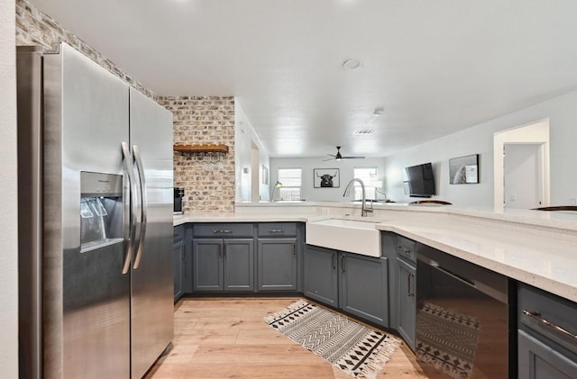 7004 Ashen Ln, Austin, TX 78747 - kitchen featuring stainless steel fridge, dishwasher, gray cabinets, and light wood-style floors
