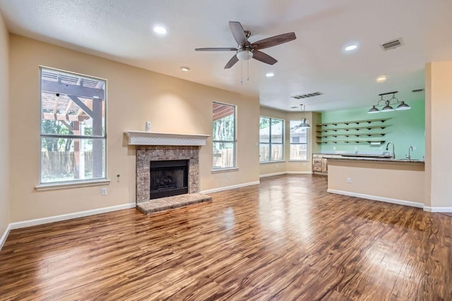 2708 Winding Brook Dr, Austin, TX 78748 - unfurnished living room with wood finished floors, a brick fireplace, baseboards, recessed lighting, and ceiling fan