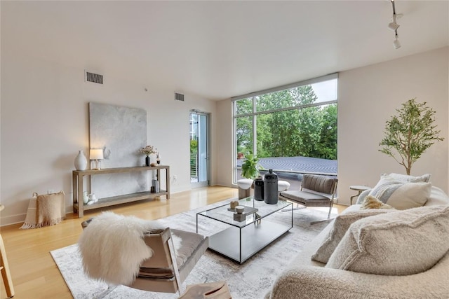 210 Lee Barton Dr Unit 308, Austin, TX 78704 - living room with visible vents, rail lighting, baseboards, and wood finished floors